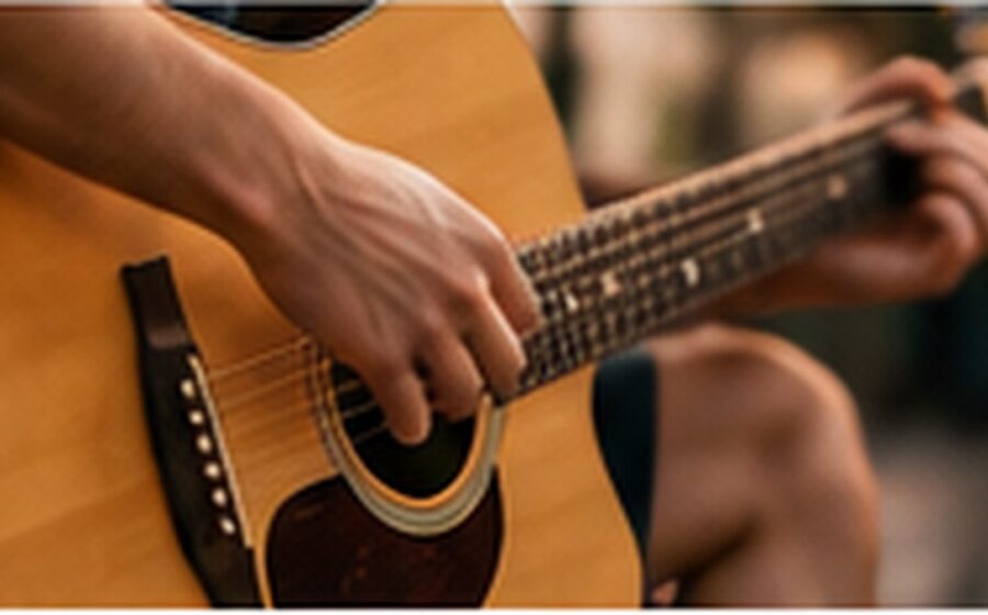 Músico tocando violão em apresentação ao vivo